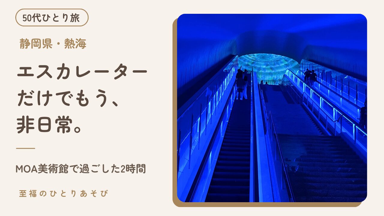 青い光のトンネルの奥に円形の万華鏡のプロジェクションマッピングが見えるMOA美術館のエスカレーター内観写真に、タイトルと「50代ひとり旅」のバッジを重ねた、MOA美術館訪問記のアイキャッチ画像